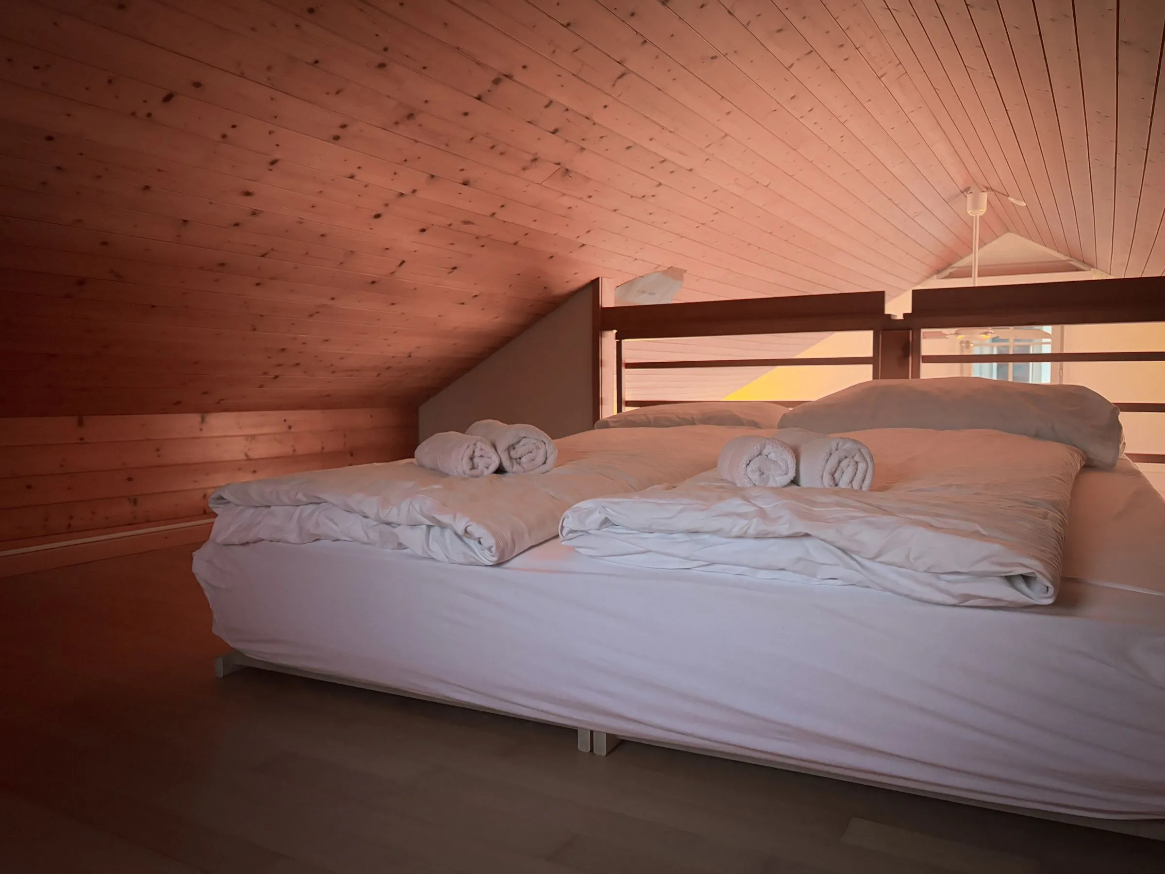 A loft bedroom under a timber ceiling
